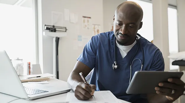 Doctor in scrubs with digital tablet and clipboard